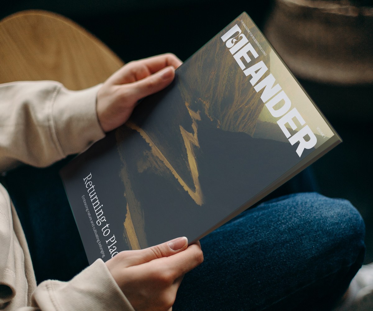 Hands holding an issue of Meander magazine